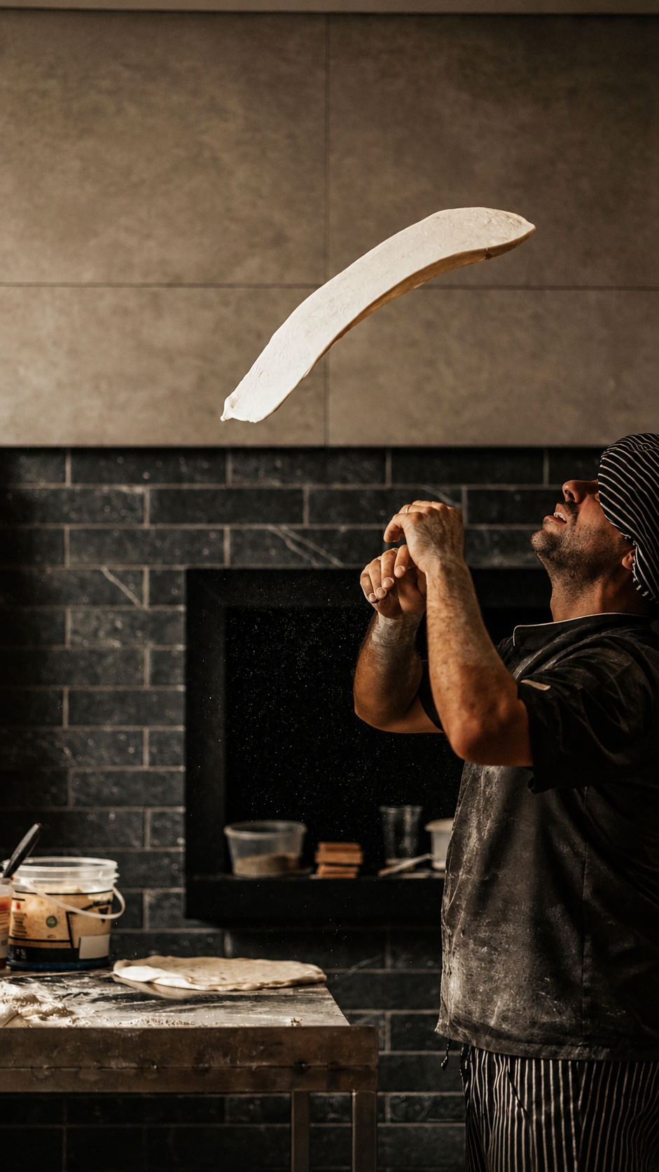 Pizzaiolo da Uomo Pizza lançando a massa ao ar